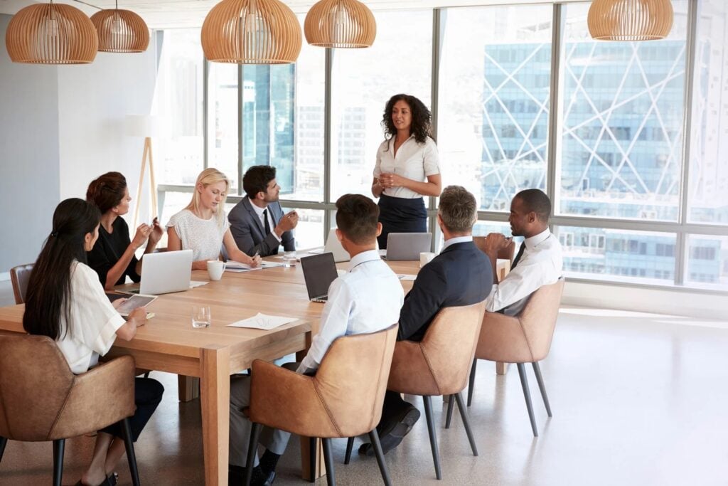 Diverse executive leadership team in a strategy meeting around a conference table in a modern boardroom