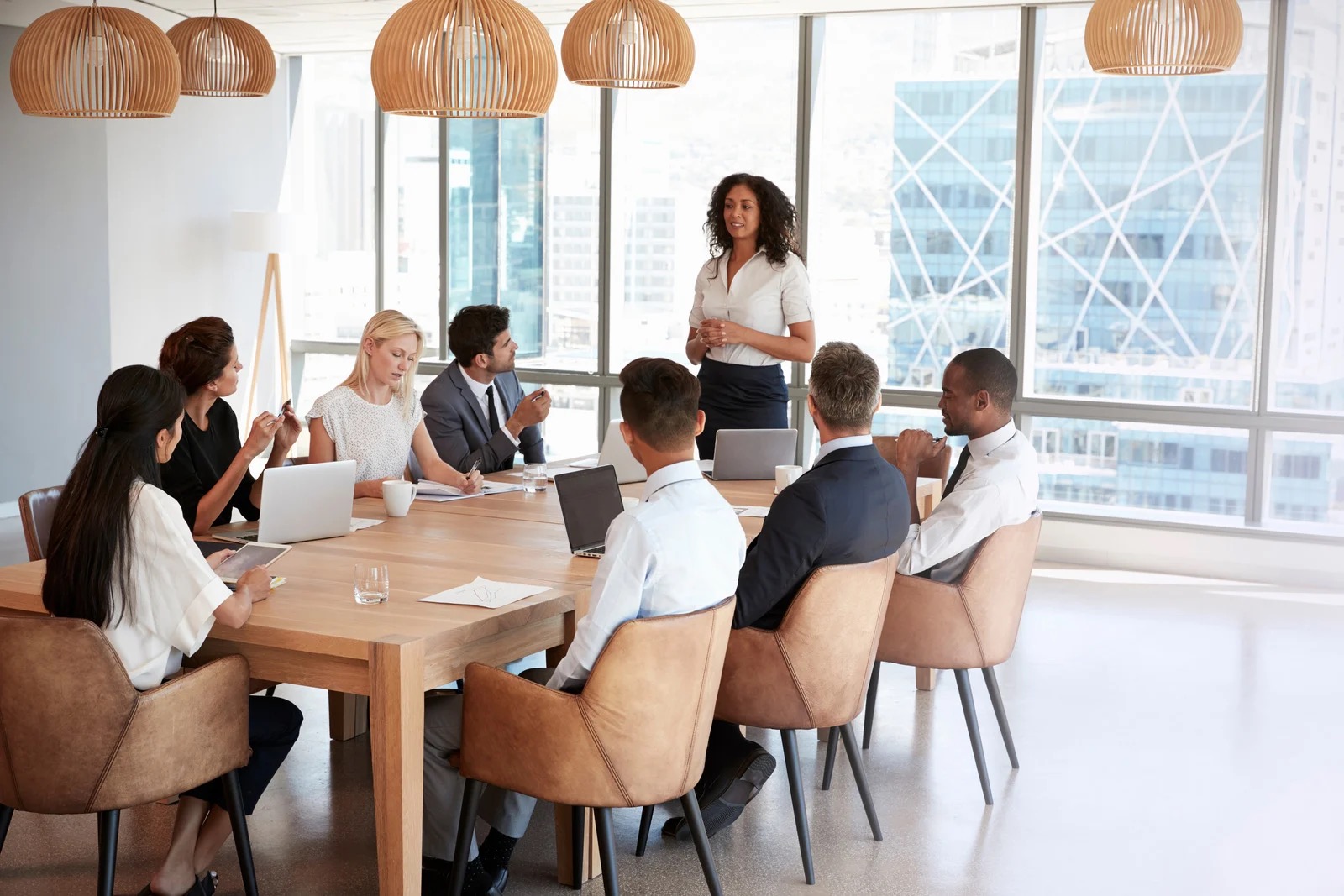 Diverse executive leadership team in a strategy meeting around a conference table in a modern boardroom